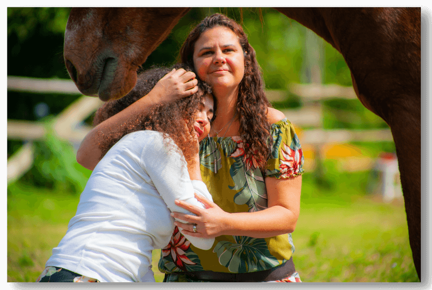 Sílvia Calian acolhendo uma participante junto aos cavalos